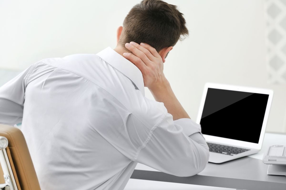 Impiegato soffre mal di collo davanti al pc