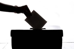 mano che mette scheda elettorale nell'urna