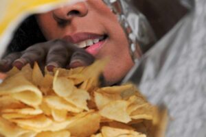 Donna guarda dentro un sacchetto di patatine