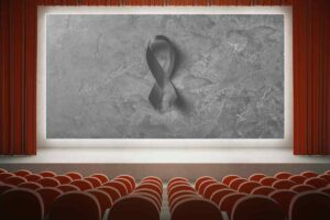 Una sala cinematografica e sullo schermo il fiocco del lutto