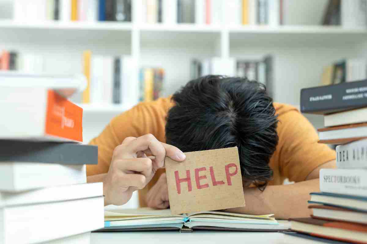Studente chino sui libri che chiede aiuto