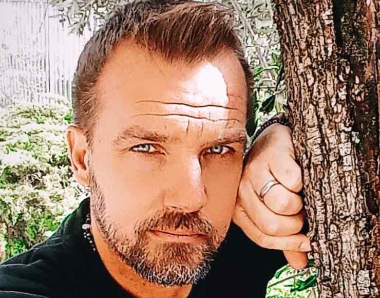 danilo brugia poggiato a un albero