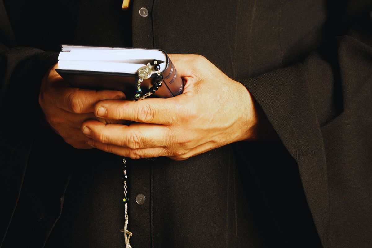 prete con la bibbia in mano